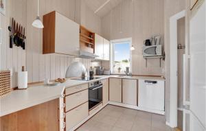 a kitchen with white cabinets and a stove top oven at Holiday Home Bunken 7 in Ålbæk