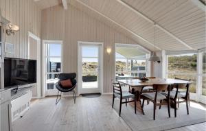 a kitchen and dining room with a table and chairs at Holiday Home Bunken 7 in Ålbæk