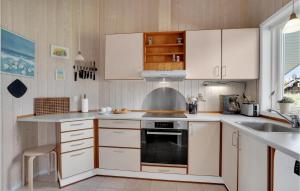 a kitchen with white cabinets and a sink at Holiday Home Bunken 7 in Ålbæk