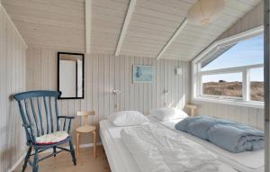 a bedroom with a bed and a chair and a window at Holiday Home Bunken 7 in Ålbæk +11 photos