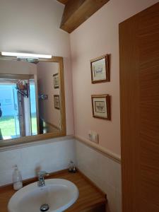 a bathroom with a sink and a mirror at Cabaña rústica playa Area, Viveiro, Lugo in Lago +5 photos