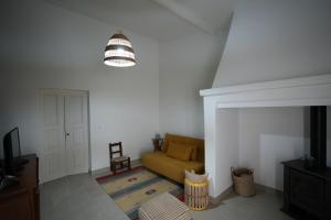 ein Wohnzimmer mit einem gelben Sofa und einer Lampe in der Unterkunft Casa da Avó Júlia Pestana (Piscina privada) in Torrão