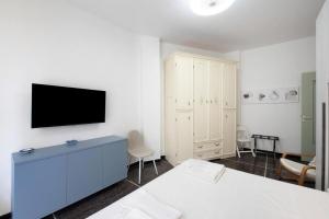 een slaapkamer met een tv aan een witte muur bij Casa Sole Luna in Arenzano