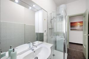 een witte badkamer met een wastafel en een douche bij Casa Sole Luna in Arenzano +12 foto's