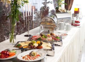 a buffet with many plates of food on a table at Hotel Unique Majestic in Dortmund