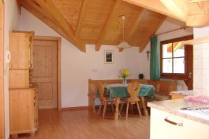 cocina y comedor con mesa y sillas en Oberlindnerhof en San Lorenzo di Sebato