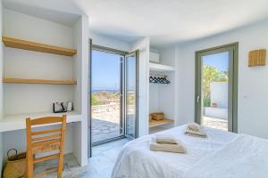 ein Schlafzimmer mit Bett und Meerblick in der Unterkunft Stone Pine House Antiparos - Private Pool Villa in Andiparos
