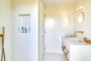 ein weißes Badezimmer mit Waschbecken und Spiegel in der Unterkunft Stone Pine House Antiparos - Private Pool Villa in Andiparos + 42 Fotos