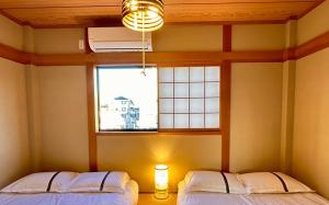 two beds in a room with a window at 随心居 in Osaka