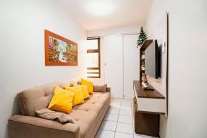 a living room with a couch with yellow pillows at OZPED Flats Particulares Condomínio Mont Serrat in Brasilia