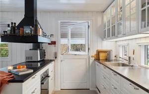a kitchen with white cabinets and a sink at 4 Bedroom Gorgeous Home In Hornbæk in Hornbæk