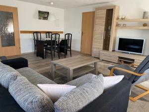 a living room with a couch and a table at FeWo - "Am Schwedenstein" 85qm - bis 5 Personen in Ohorn