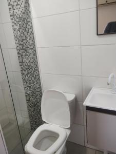 a bathroom with a toilet and a sink at Pousada Maranata Canoas in Canoas