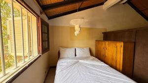 Un dormitorio con una cama en una habitación con ventanas. en charmante villa en résidence en bord de mer, en Saly Portudal 11 fotos más