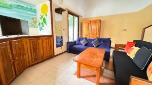 Una sala de estar con un sofá azul y una mesa. en charmante villa en résidence en bord de mer, en Saly Portudal