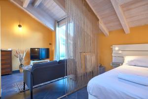 a bedroom with a bed and a couch and a tv at Italianway - Tra le Torri in Albenga