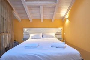 a bedroom with a large white bed with two pillows at Italianway - Tra le Torri in Albenga +37 photos