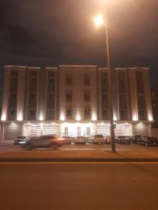 a building with a street light in front of a parking lot at Riyadh luxury family Apartment AlYasmin in Riyadh