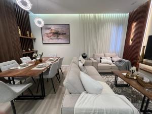 a living room with a couch and a dining room at Riyadh luxury family Apartment AlYasmin in Riyadh