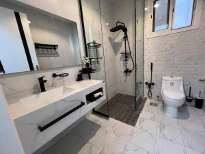 a white bathroom with a shower and a toilet at Riyadh luxury family Apartment AlYasmin in Riyadh +48 photos