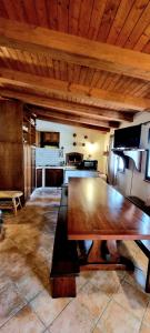 a large wooden table in a room with a kitchen at splendido open space in Villa Veronica Porto Istana in Porto Istana