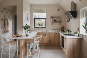a kitchen with wooden cabinets and a table and chairs at Eve in Marlborough +3 photos
