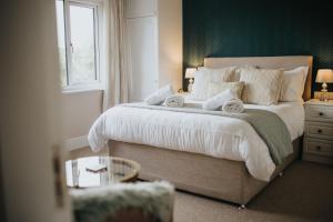 Un dormitorio con una cama grande con toallas. en Ferlas Bed and Breakfast, en Penrhyndeudreath