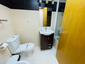 a bathroom with a white toilet and a sink at Jardines de Veneciola by Alina365 in La Manga del Mar Menor +23 photos