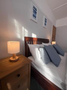 a bedroom with a bed with a lamp on a dresser at The Grenadine House in South Norwood