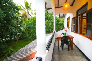 a balcony of a house with a table and chairs at Green View Apartment in Unawatuna