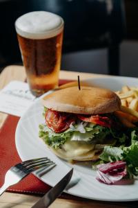 Un sándwich y papas fritas y un vaso de cerveza. en Hôtel Le Christania, en Bellevaux