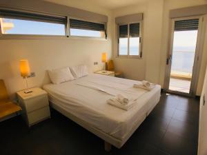 sypialnia z białym łóżkiem i ręcznikami na nim w obiekcie La Manga Beach Club Frontal by Alina365 w mieście La Manga del Mar Menor