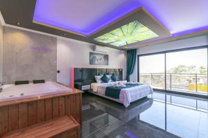 a bedroom with a bed and a tub and a window at Villa Yeşim in Kas +48 photos