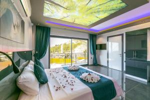 a bedroom with a large bed and a ceiling with a painting at Villa Yeşim in Kas