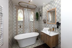 a bathroom with a tub and a sink and a mirror at Appartement Jardin La Bohémienne du Mandara Beach , Juan-les-Pins, Cote d Azur in Juan-les-Pins +6 photos