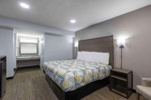 una habitación de hotel con una cama y un espejo en Motel 6 Hickory NC, en Hickory