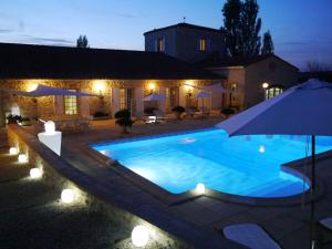 uma piscina com um guarda-sol em frente a uma casa em Chambres d'Hôtes Domaine de Beunes em Pailloles