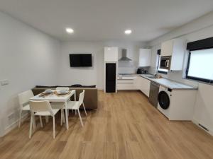 a kitchen and living room with a table and chairs at Apartamentos VALDECILLA nuevos in Santander