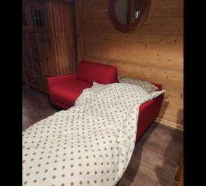 een rood bed en een rode stoel in een kamer bij Couleurs des Alpes Au pied des pistes de Sommand Praz de Lys in Sommand +12 foto's