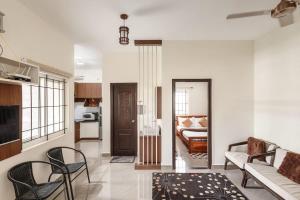 a living room with a couch and a bed at Blue Nest By StayJadeParty VillaLawn in Hosūr