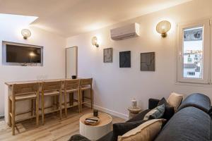 een woonkamer met een bank en een tafel bij MEY T2 - Superbe appartement 4 pers, 50m du vieux port et 2min à pied du palais in Cannes