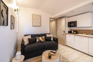 een woonkamer met een bank en een keuken bij MEY T2 - Superbe appartement 4 pers, 50m du vieux port et 2min à pied du palais in Cannes