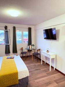 a hotel room with a bed and a desk and a tv at Le Ti Marinois 5 in Le Marin
