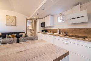 een keuken met witte kasten en een woonkamer bij MEY T2 - Superbe appartement 4 pers, 50m du vieux port et 2min à pied du palais in Cannes +10 foto's