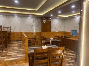 a restaurant with wooden tables and chairs and a counter at Hotel Middle Temple Pvt Ltd in Kathmandu