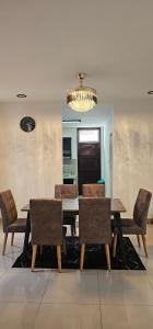 a dining room with a table and chairs and a chandelier at Suria Aman Homestay Semi-D 5 Rooms 5 Bathrooms in Taiping