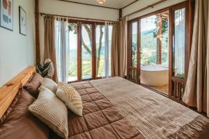 a bedroom with a large bed with a large window at Wintery House in Ban Thung Phan Ha
