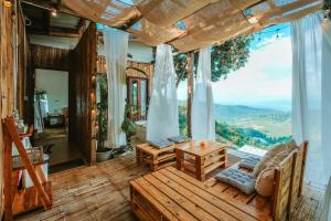 a room with a table and chairs and a large window at Wintery House in Ban Thung Phan Ha