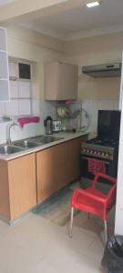 a kitchen with a sink and a red stool at Gramaxkenya in Nairobi +3 photos
