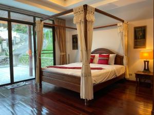 a bedroom with a bed with a canopy at Вилла в сердце Пхукета in Ban Lum Fuang +8 photos